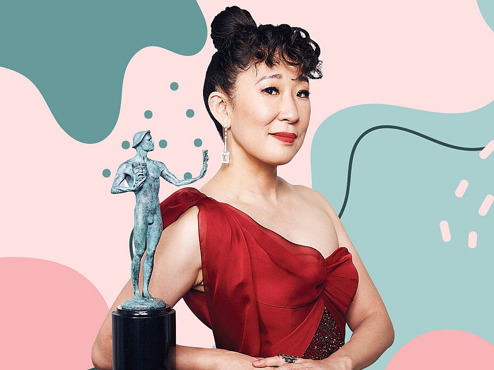 Sandra Oh'un bir ödülün yanında poz veren kırmızı elbiseli görüntüsü