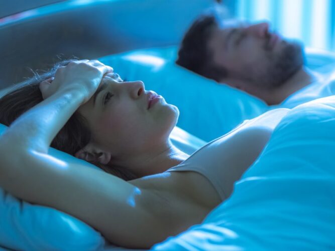 Uykusuzluk çeken kadın, yatakta adamın yanında yatıyor. gece vakti